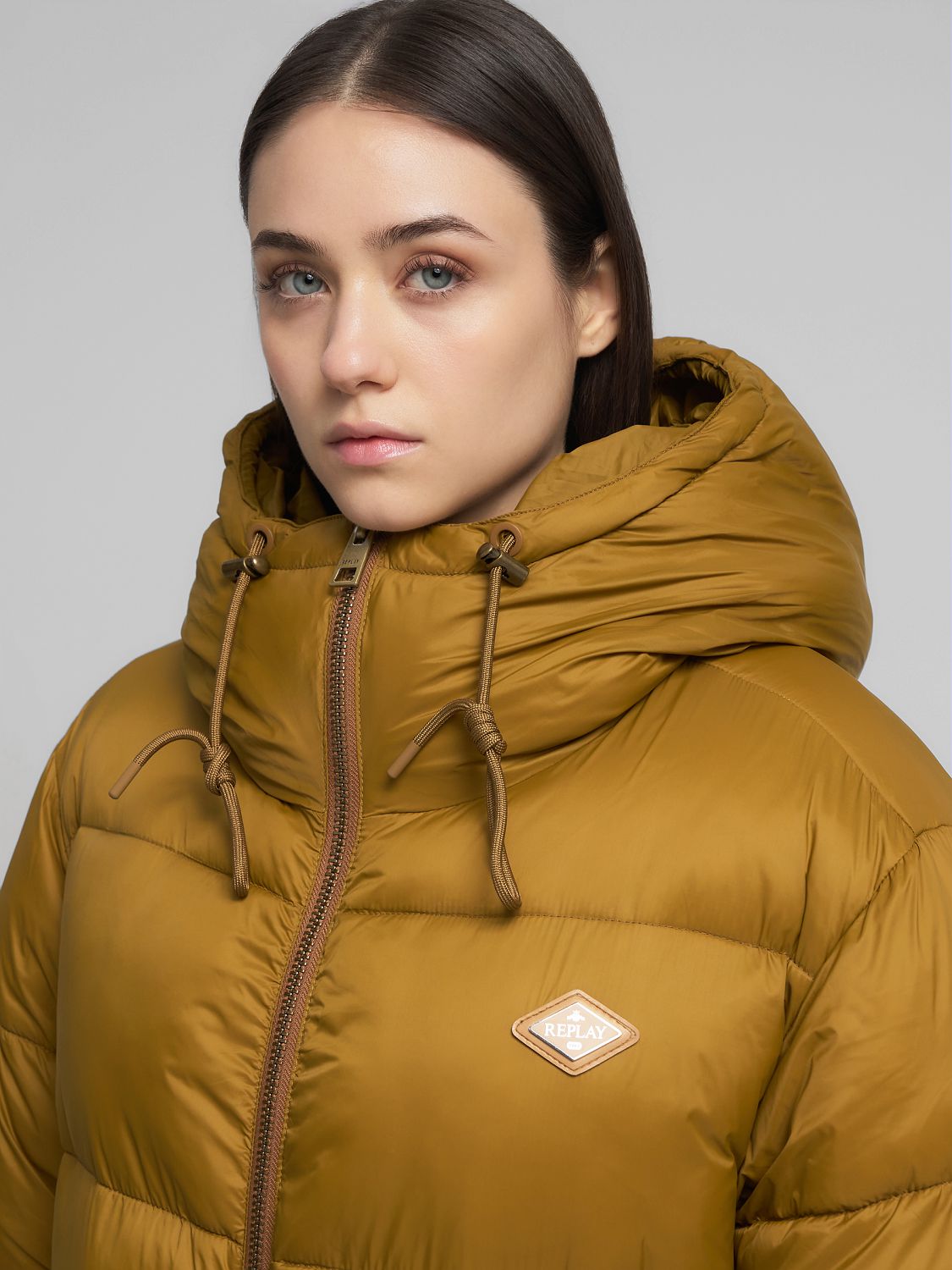 Dlouhá bunda s kapucí, rozparky a postranními kapsami