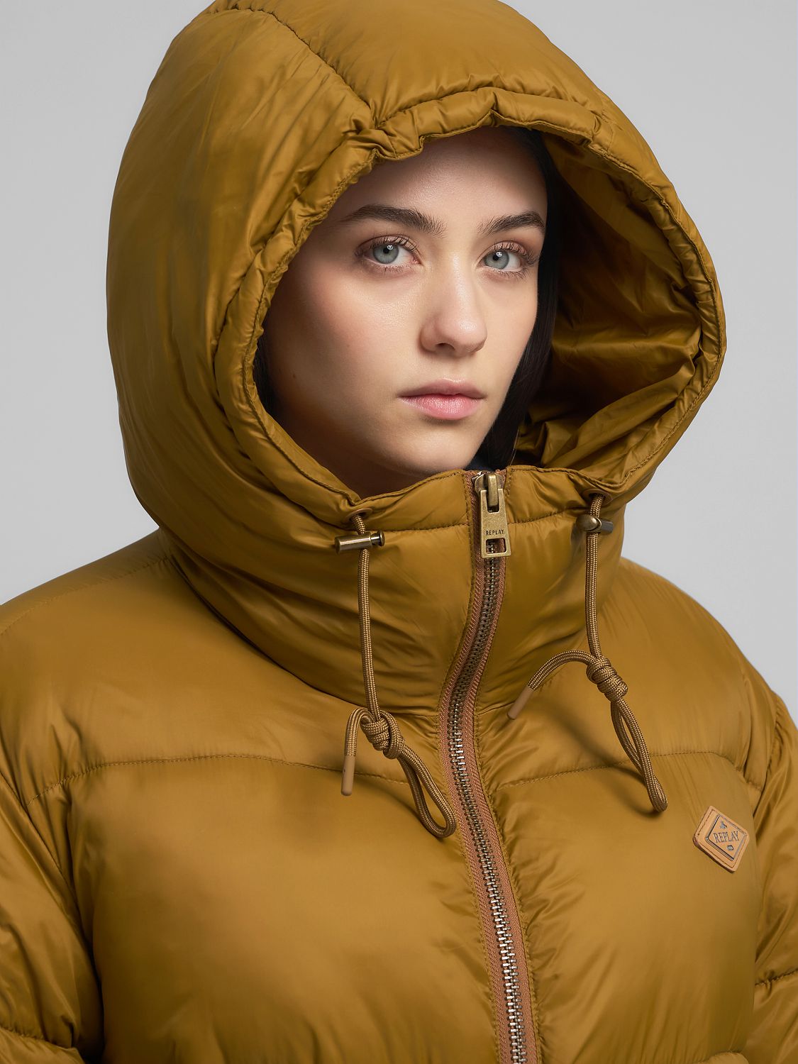 Dlouhá bunda s kapucí, rozparky a postranními kapsami