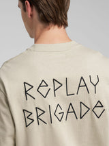 Tričko s grafikou na hrudi a nápisem „Replay Brigade“ na zádech